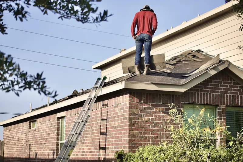 Professional roofer working on a residential roof in Hempstead Gardens